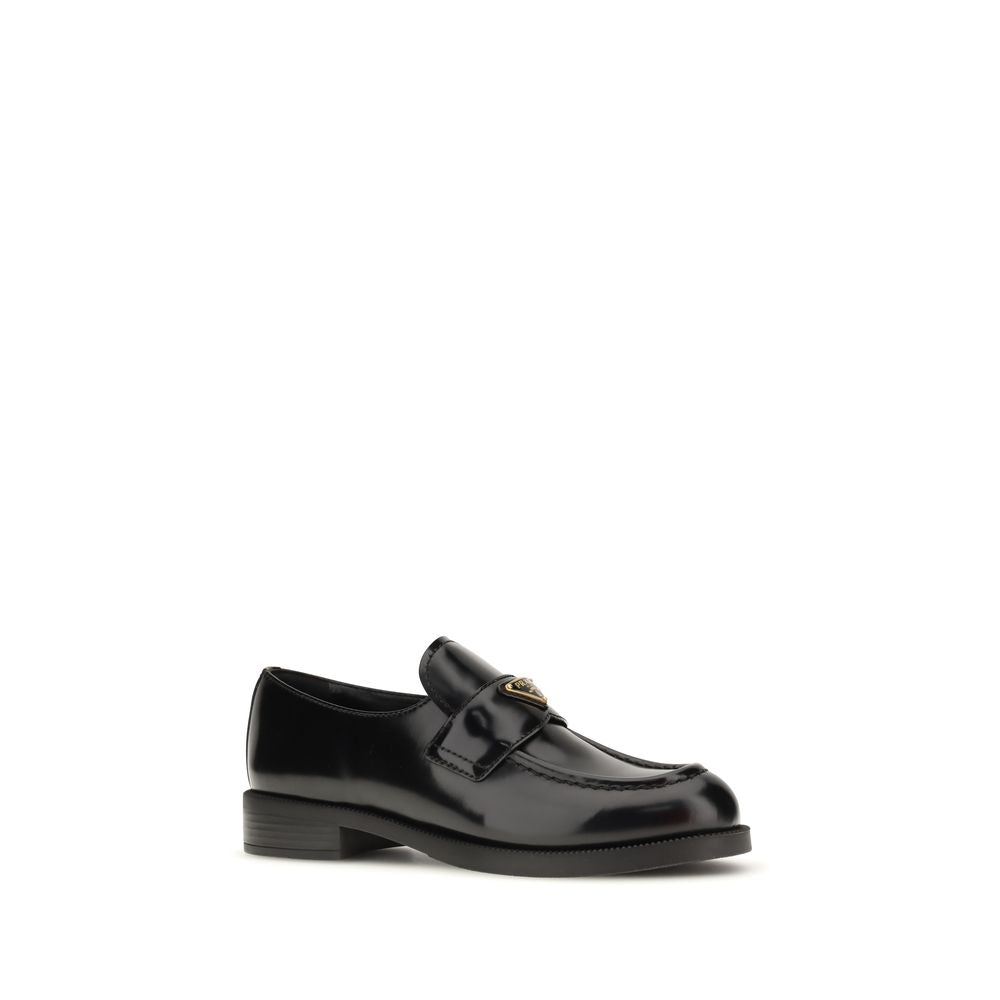 Prada Loafers Neri in Pelle Lucida Logo Triangolo Metallico SS26