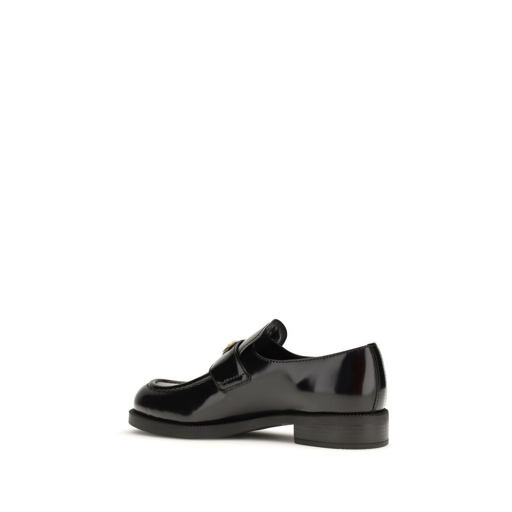 Prada Loafers Neri in Pelle Lucida Logo Triangolo Metallico SS26